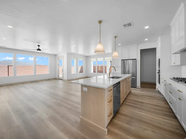 Open-concept living space with wood-finish flooring, recessed lighting, and a modern ceiling fan