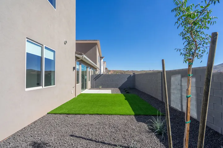 Backyard sanctuary featuring a manicured lawn with fresh sod, gravel hardscaping, and perimeter fencing