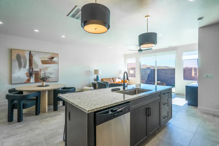 Modern kitchen island with quartzite countertop and black cabinetry anchors this open-concept space