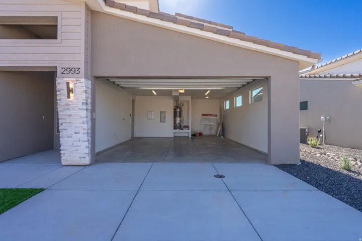Attached two-car garage with concrete flooring and multiple windows for natural light