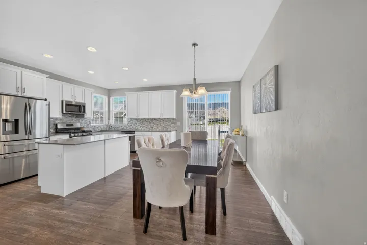 Open-concept living space with wood-finish flooring, recessed lighting, and a sliding glass door