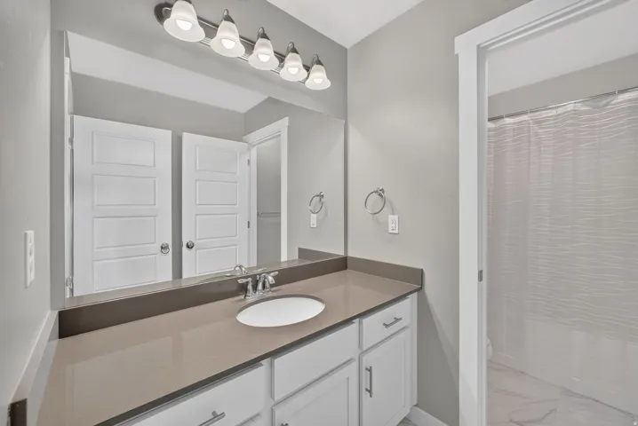 Spacious vanity with a light gray countertop, undermount sink, and chrome fixtures