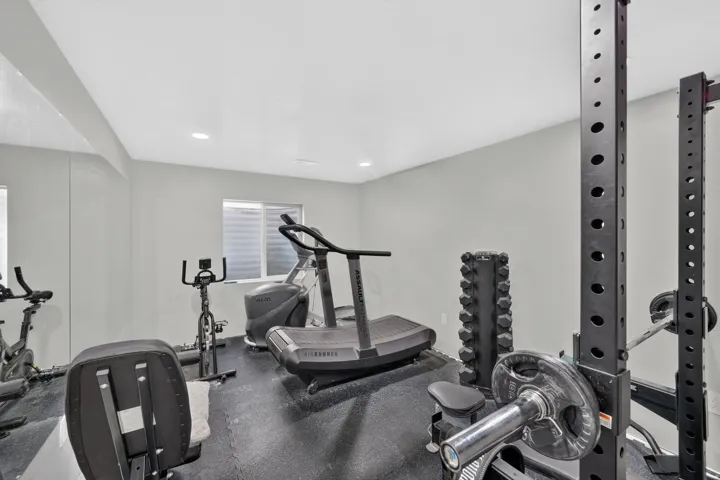 Dedicated fitness space featuring rubberized flooring, recessed lighting, and ample wall space
