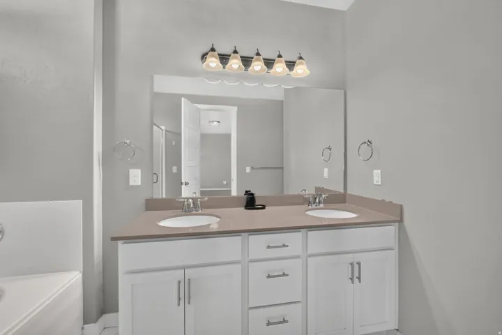 Double vanity with white cabinetry, dual undermount sinks, and a light-toned countertop