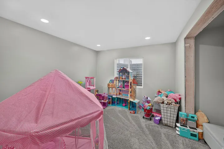Recessed lighting, light gray wall finish, window, gray carpet, and exposed structural beam