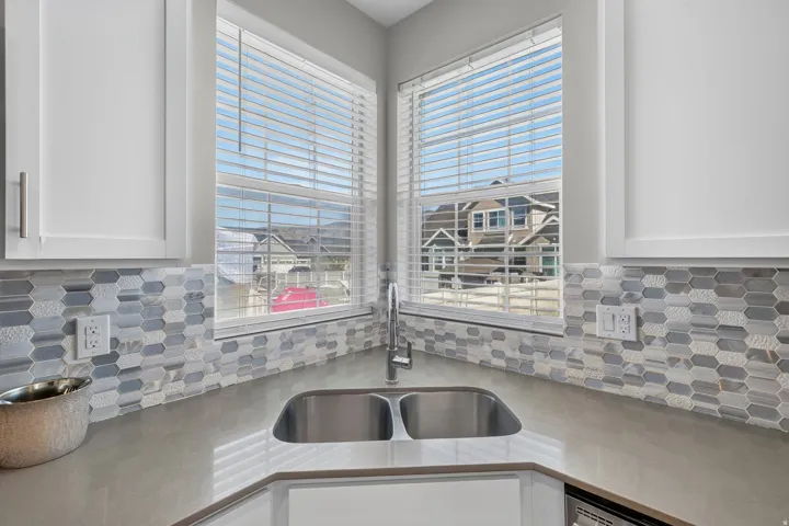 Corner stainless steel double basin sink with a chrome faucet