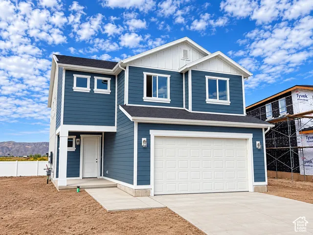 Two-story residence featuring blue siding, white trim, a two-car garage, and a covered entry