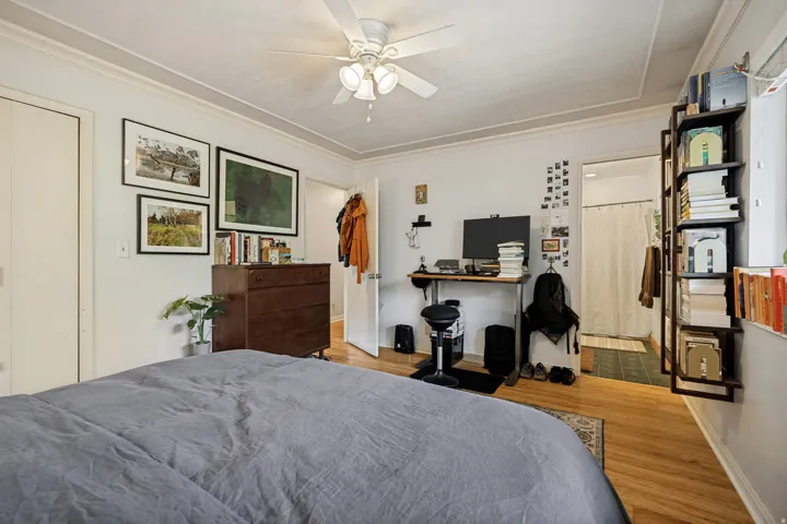 Hardwood flooring, crown molding, ceiling fan, and built-in shelving