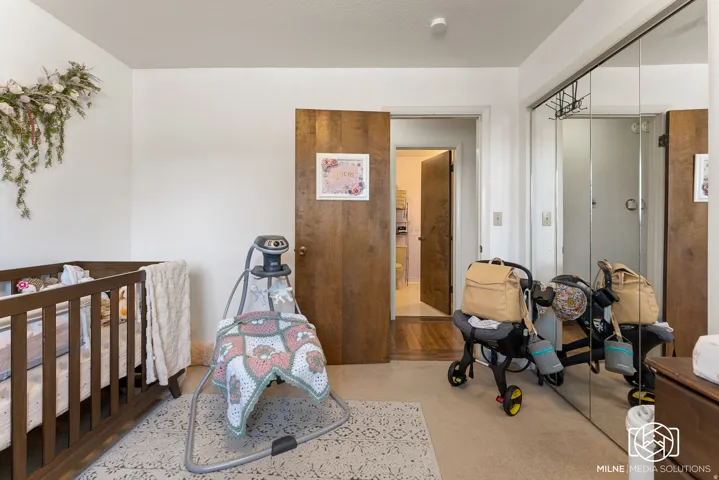 White walls, wood-finish doors, and mirrored closet doors