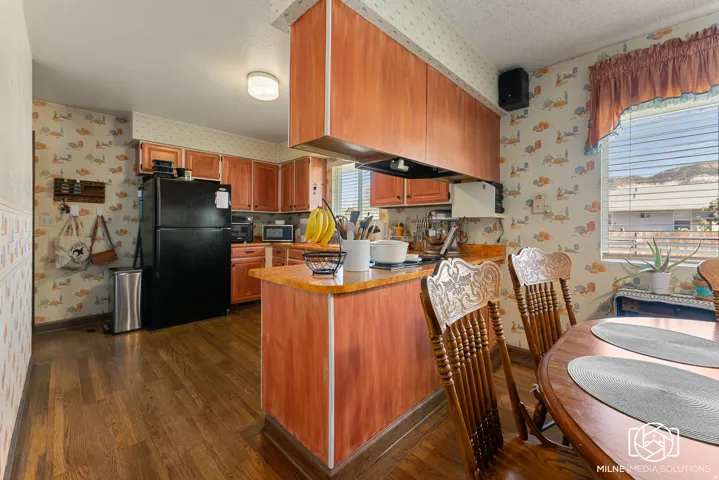 Wood-finish flooring with full-height cabinetry, an integrated kitchen island, and a built-in oven
