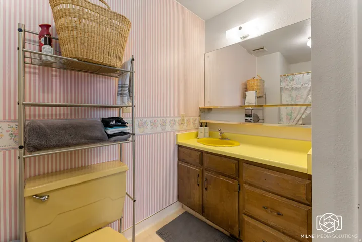 Wood-finish vanity with a yellow countertop and integrated sink