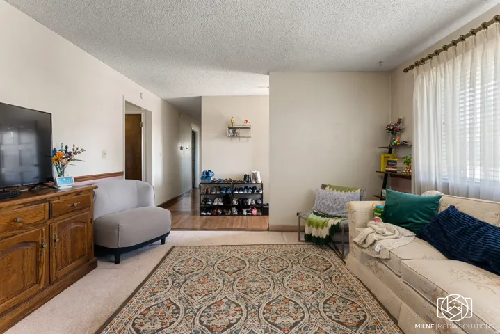 Carpeted flooring, window with blinds, and a built-in wood trim detail