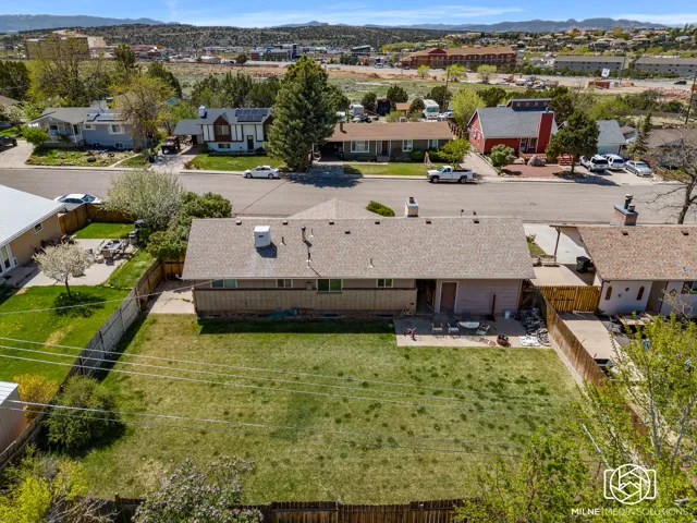 Spacious backyard with a grass lawn, fenced perimeter, and a concrete patio