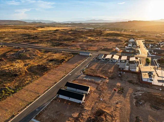 Expansive undeveloped land parcels with paved road infrastructure, surrounded by established residential properties