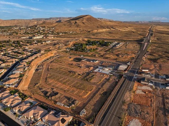 Expansive land parcel with graded lots, new road infrastructure, and established residential areas nearby
