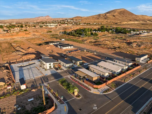 Paved parking areas, multiple residential structures, and a prominent mountain backdrop
