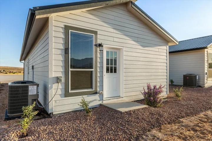 Light-colored horizontal siding exterior with a dark trim window