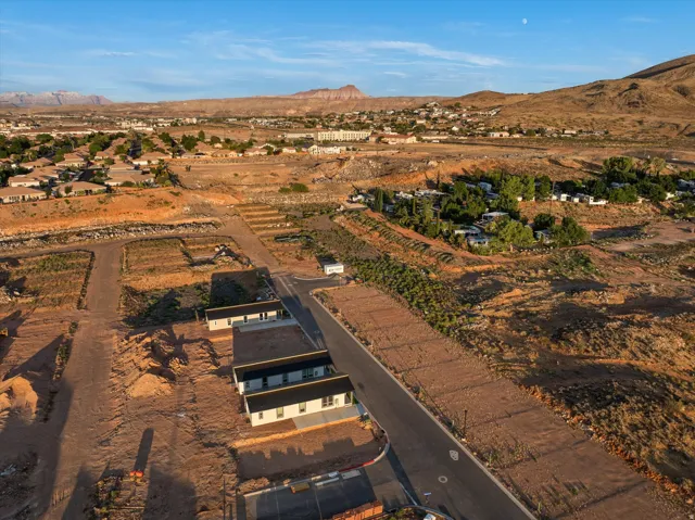 Expansive development site featuring graded lots, paved roadways, and surrounding natural landscaping