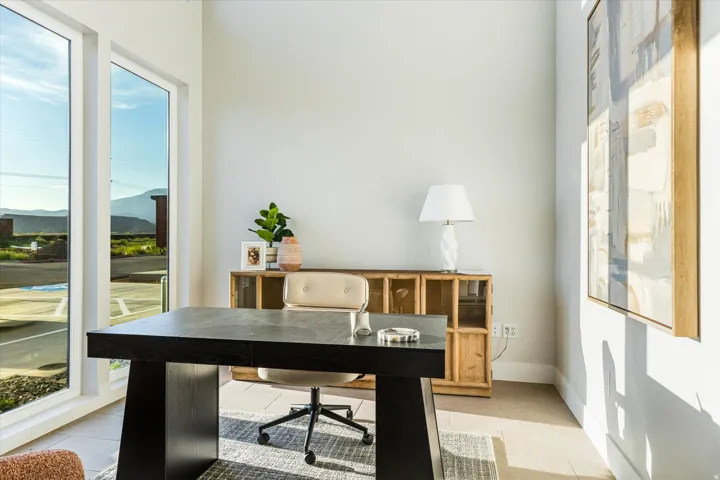 Floor-to-ceiling windows, light wood-finish flooring, and crisp white wall finishes