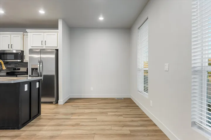 Wood-finish flooring, recessed lighting, and a window with blinds