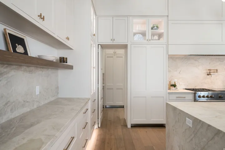White shaker-style cabinetry with gold-finish hardware