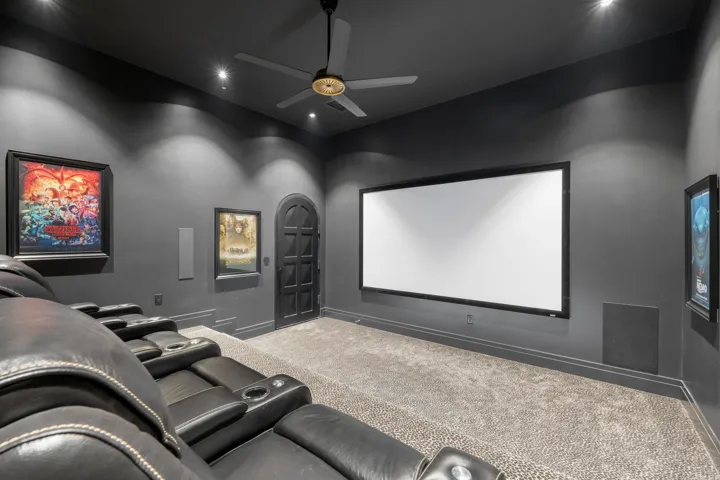 Dedicated media room featuring a large projection screen, recessed ceiling lighting, a ceiling fan, and carpeted flooring