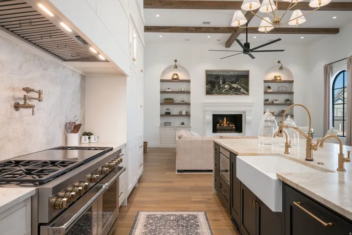Gourmet kitchen with stainless steel range, pot filler, farmhouse sink, and a large central island