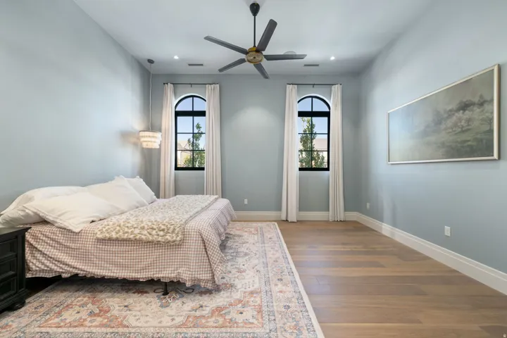 Recessed lighting, arched windows, wood-finish flooring, ceiling fan, and a built-in wall sconce