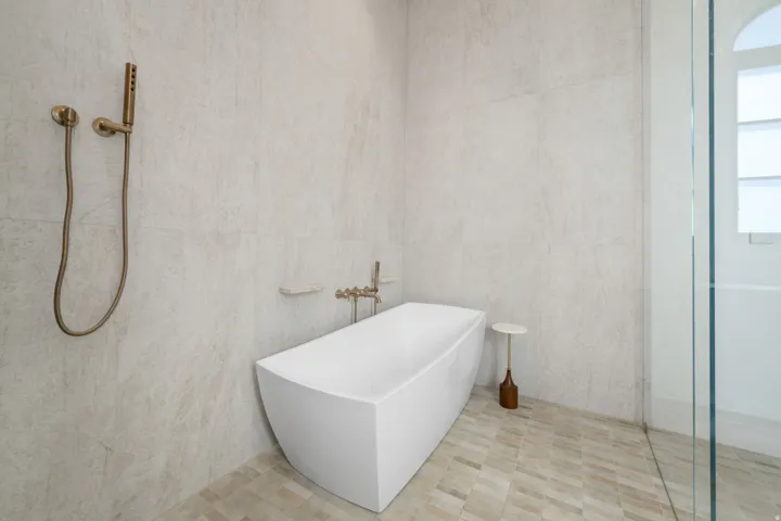 Freestanding soaking tub with floor-mounted bronzed fixtures