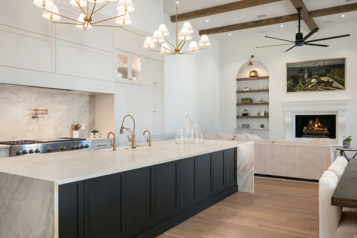 Gourmet kitchen with an expansive island, stone countertops, integrated range, and pot filler