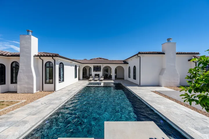 Gated pool with integrated spa and light-toned hardscaping