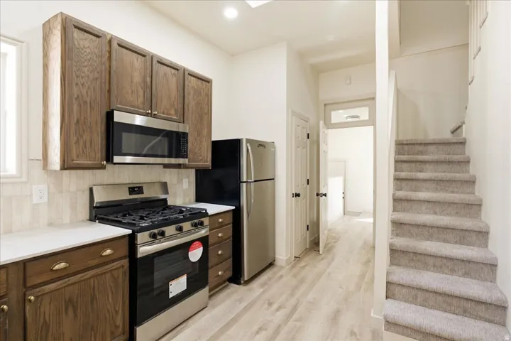 Kitchen featuring wood cabinetry, stainless steel appliances, and light countertops