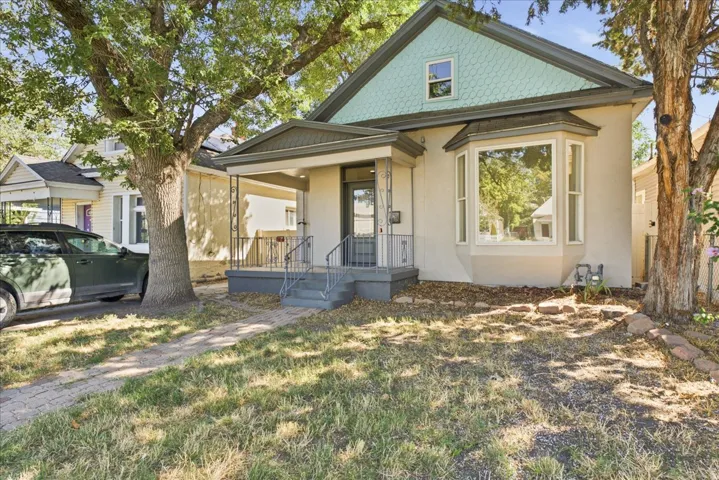 Siding exterior with a covered front porch, a bay window, and a gabled roofline with decorative shingles