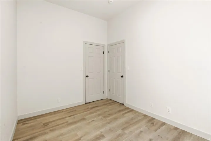 Wood-finish flooring, white walls, and white trim