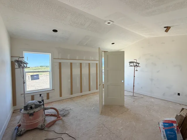 Wall paneling accent with window, angled ceiling, and recessed lighting