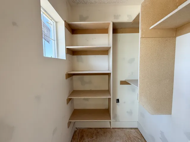 Built-in shelving units with multiple shelves, featuring a window providing natural light