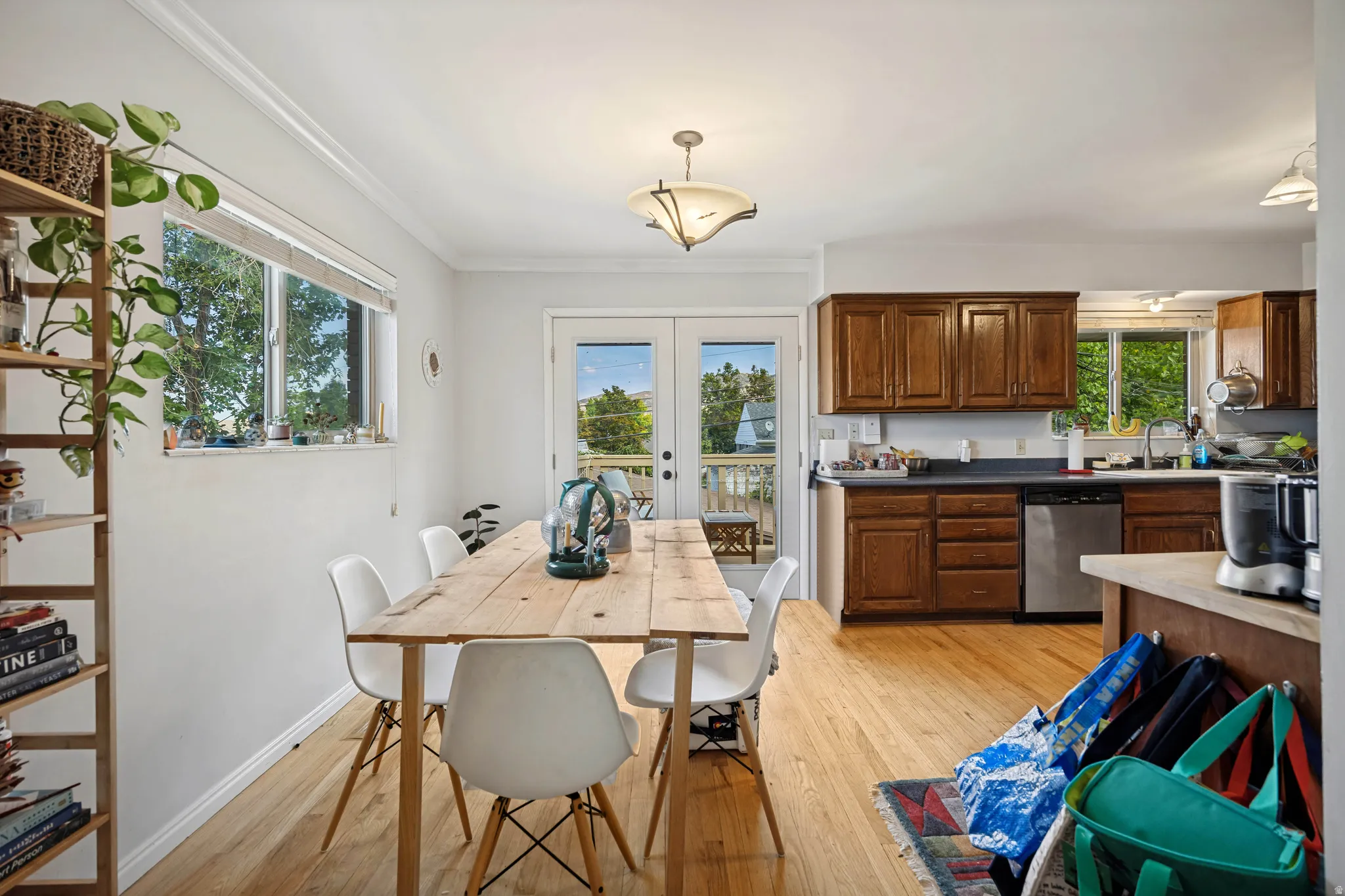 Light wood-finish flooring throughout, white painted walls, and wood-paneled kitchen cabinetry