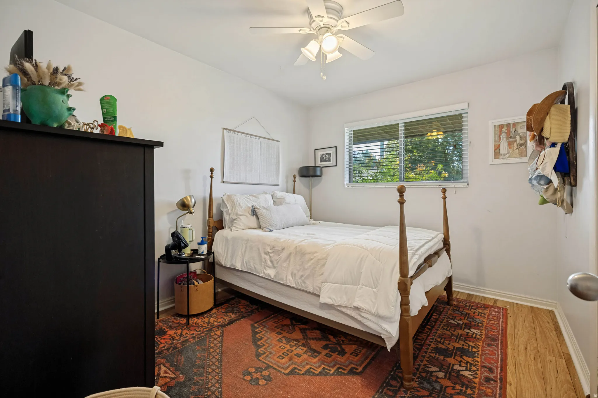 Wood-finish flooring, white walls, and a window with blinds