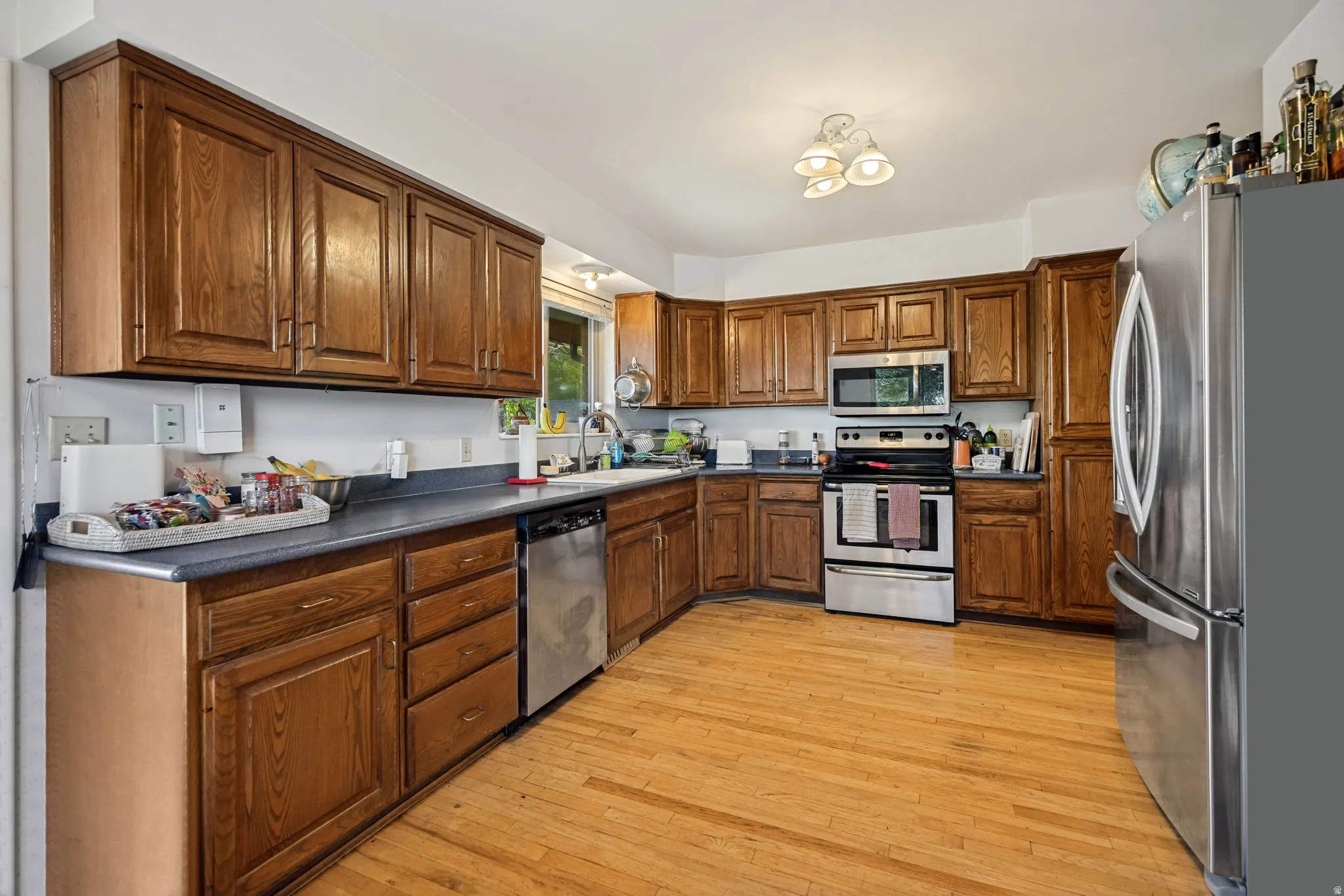 Wood-finish cabinetry, stainless steel appliances, durable countertops, wood-finish flooring, and recessed ceiling lighting