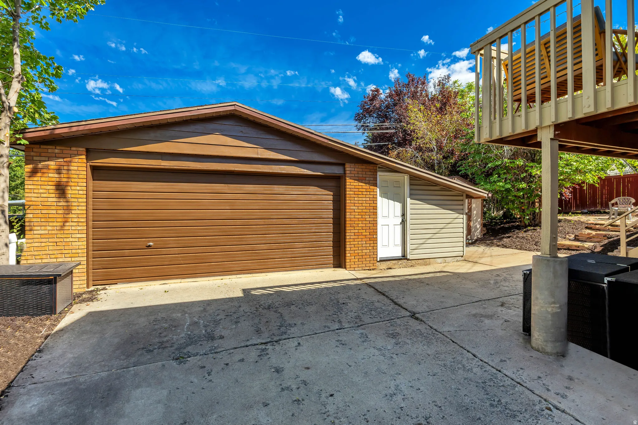 Brick and siding exterior garage with a brown sectional garage door
