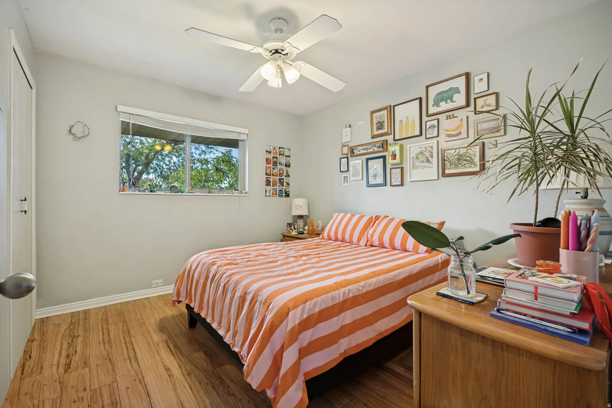 Wood-finish flooring with a ceiling fan and natural light from the window