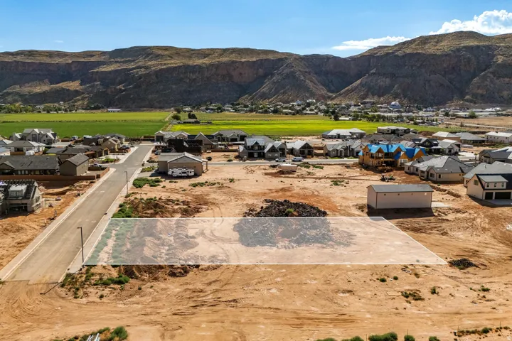 Expansive land parcel with surrounding residential development and mountain backdrop