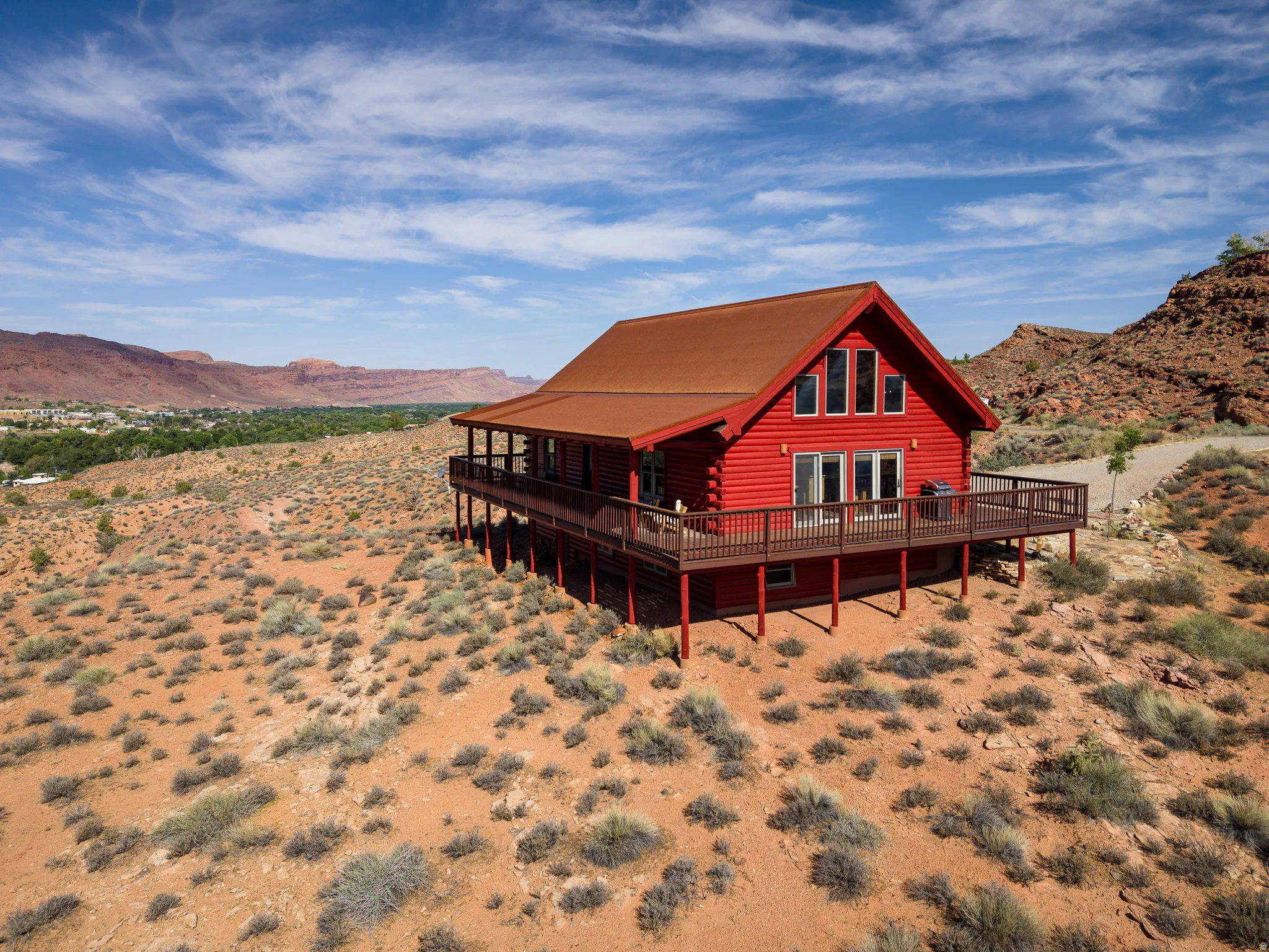 Red log cabin style residence featuring a prominent gable roof