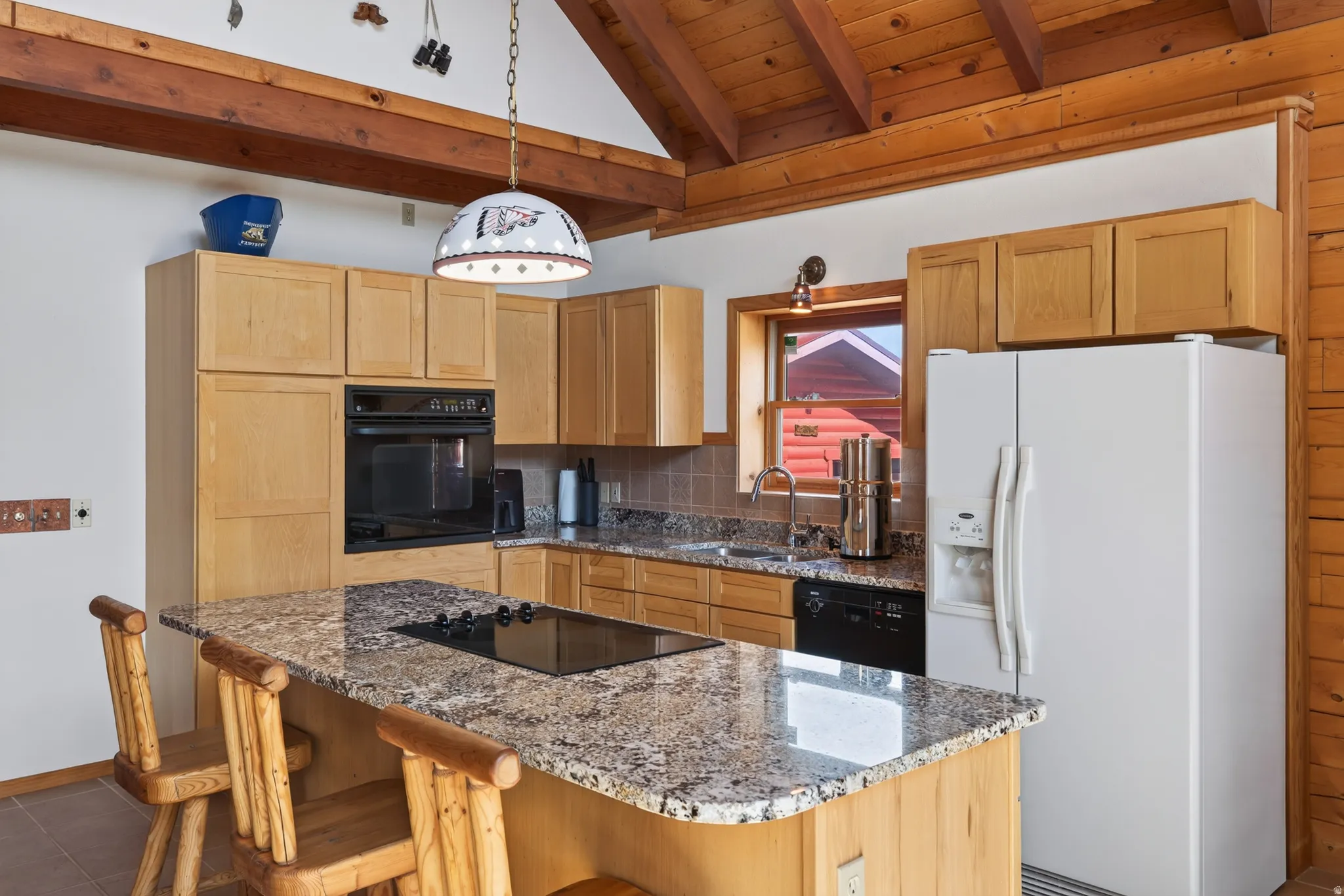 Kitchen featuring wood-finish cabinetry, built-in oven, integrated cooktop, stone-finish countertops, and exposed wood beams