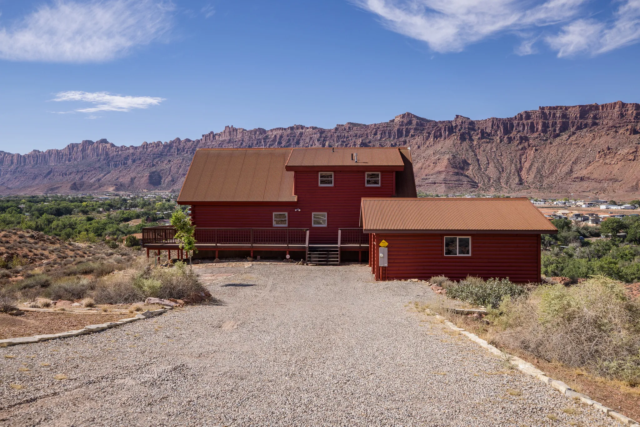 Red-sided residence with a brown roof and an attached deck