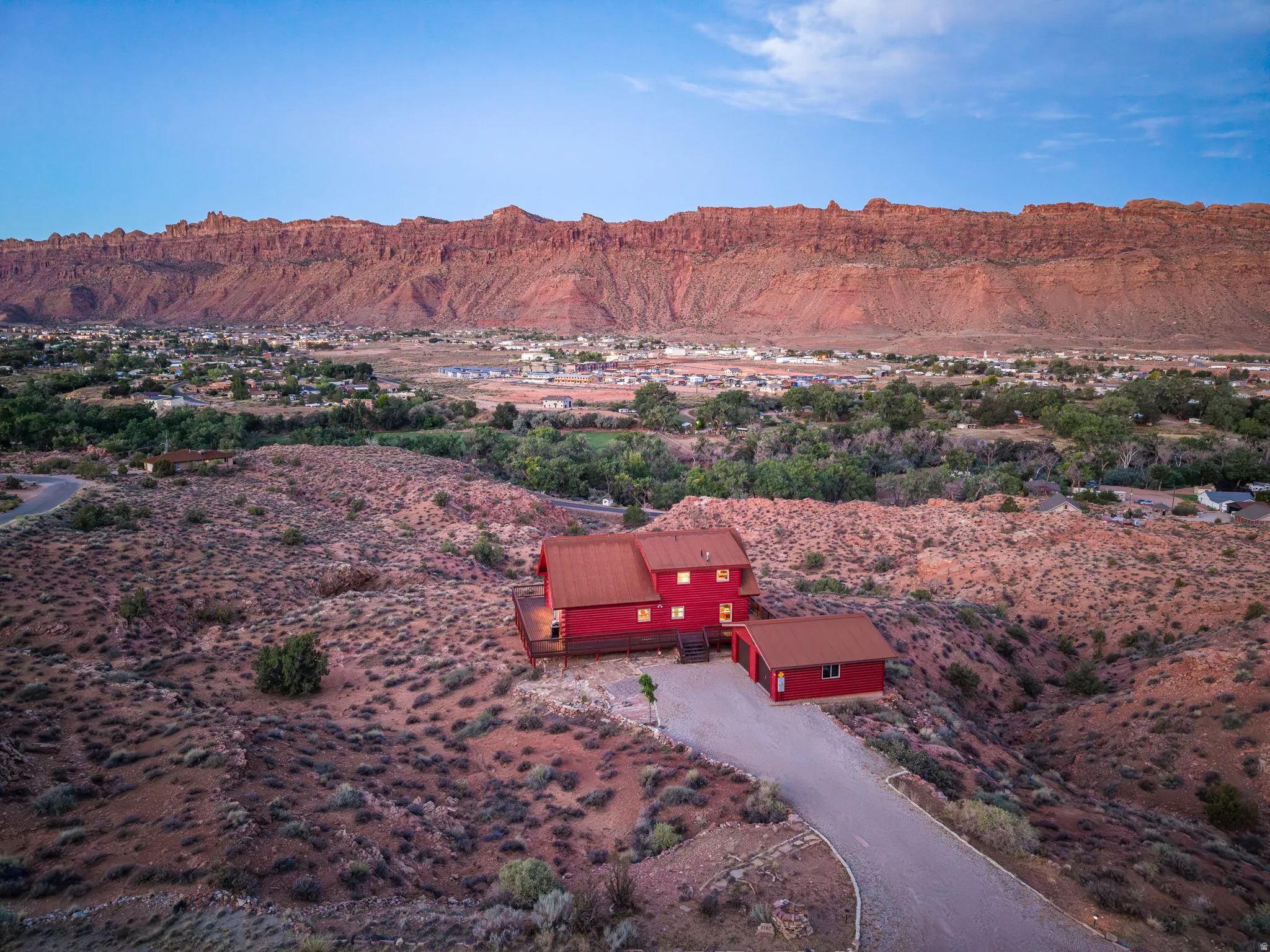 Red exterior residence with a detached garage and a metal roof