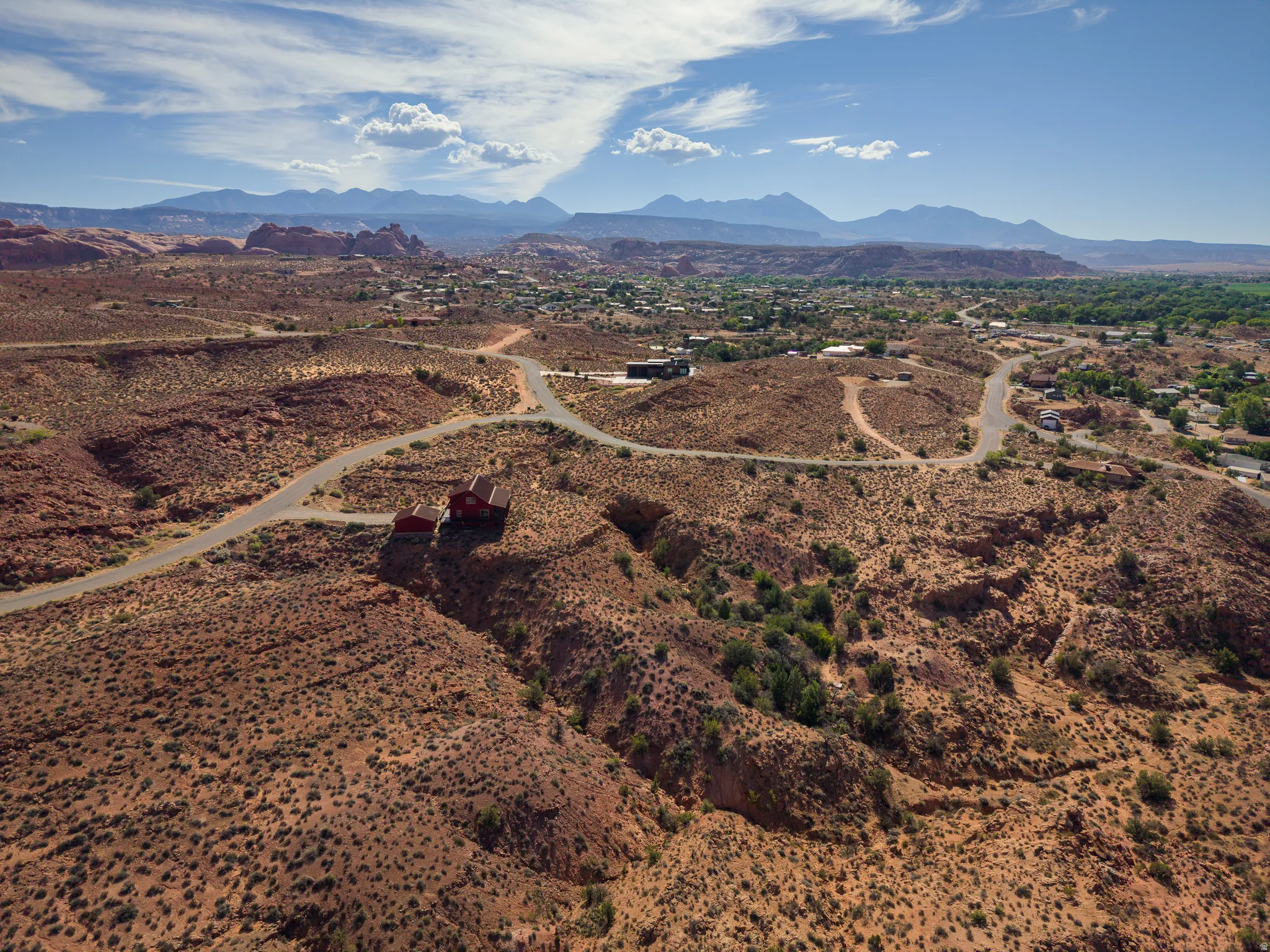 Red sandstone landscape with distant mountains under a clear sky