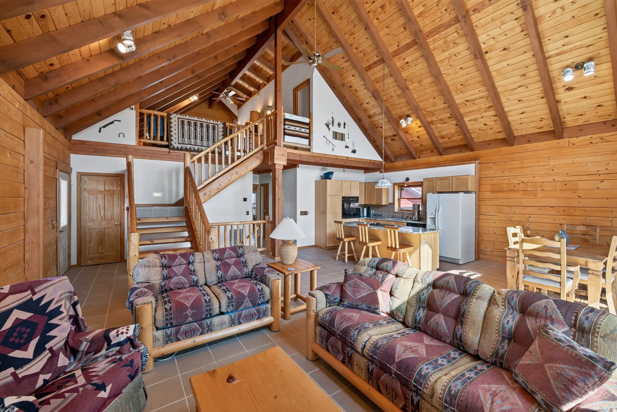 Vaulted wood-paneled ceiling with exposed beams, wood-finish walls, and a multi-level layout