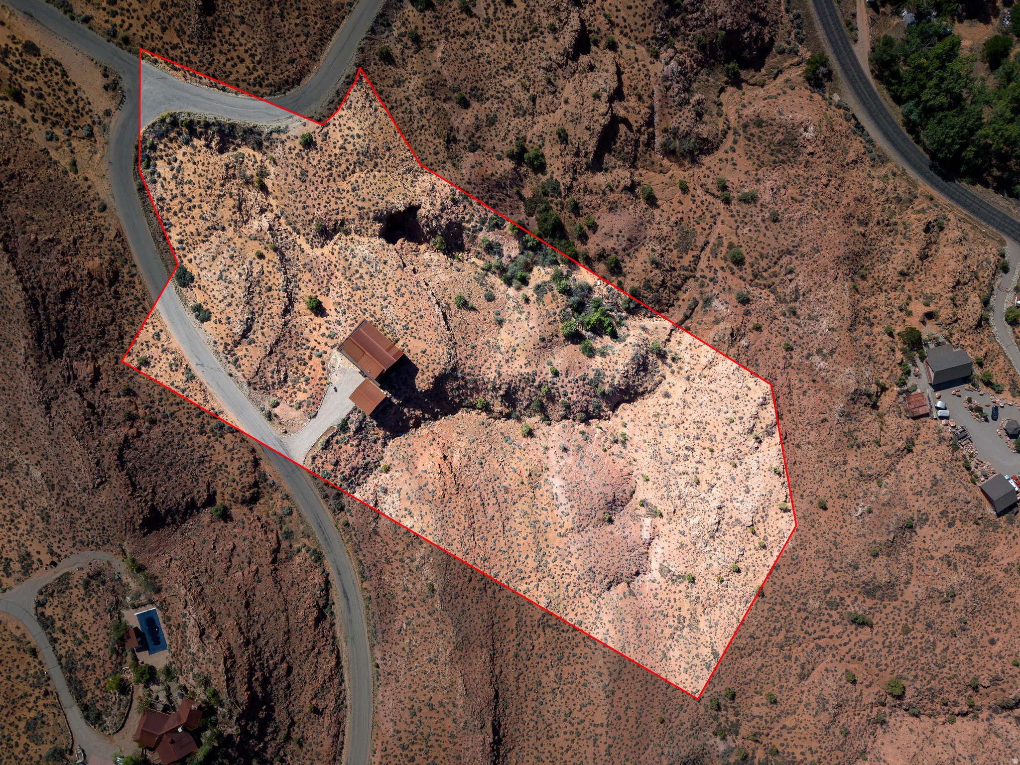 Property with a building and paved access roads, surrounded by arid landscape