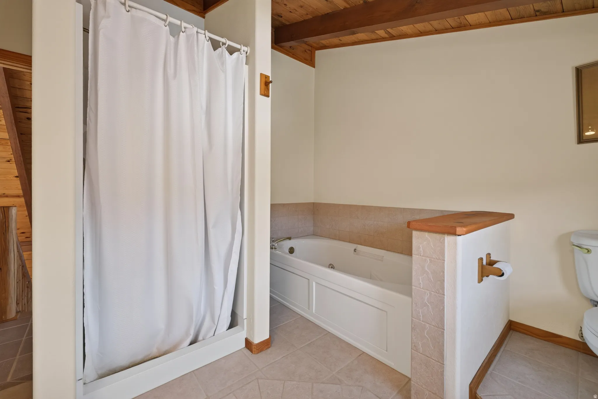 Built-in jetted tub, ceramic tile flooring, wood-finish ceiling, and a standing shower